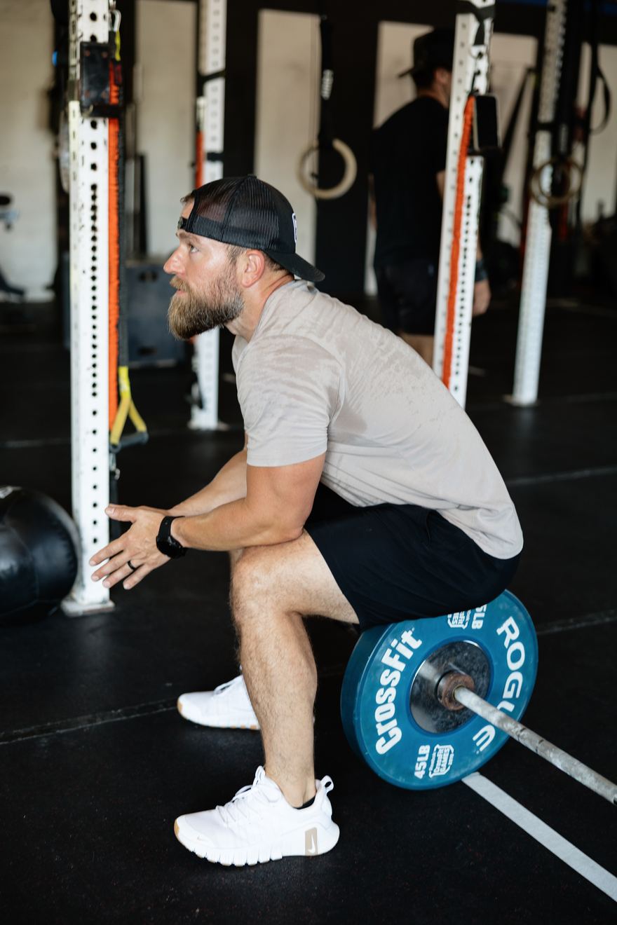 A coach talking an athlete through a lift