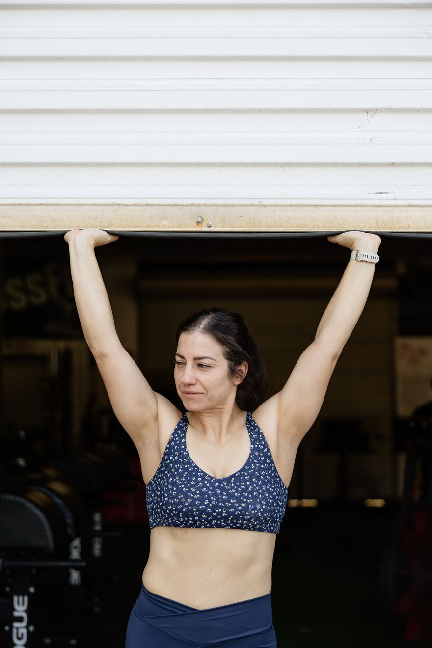 A member rolling up the gym door in the morning