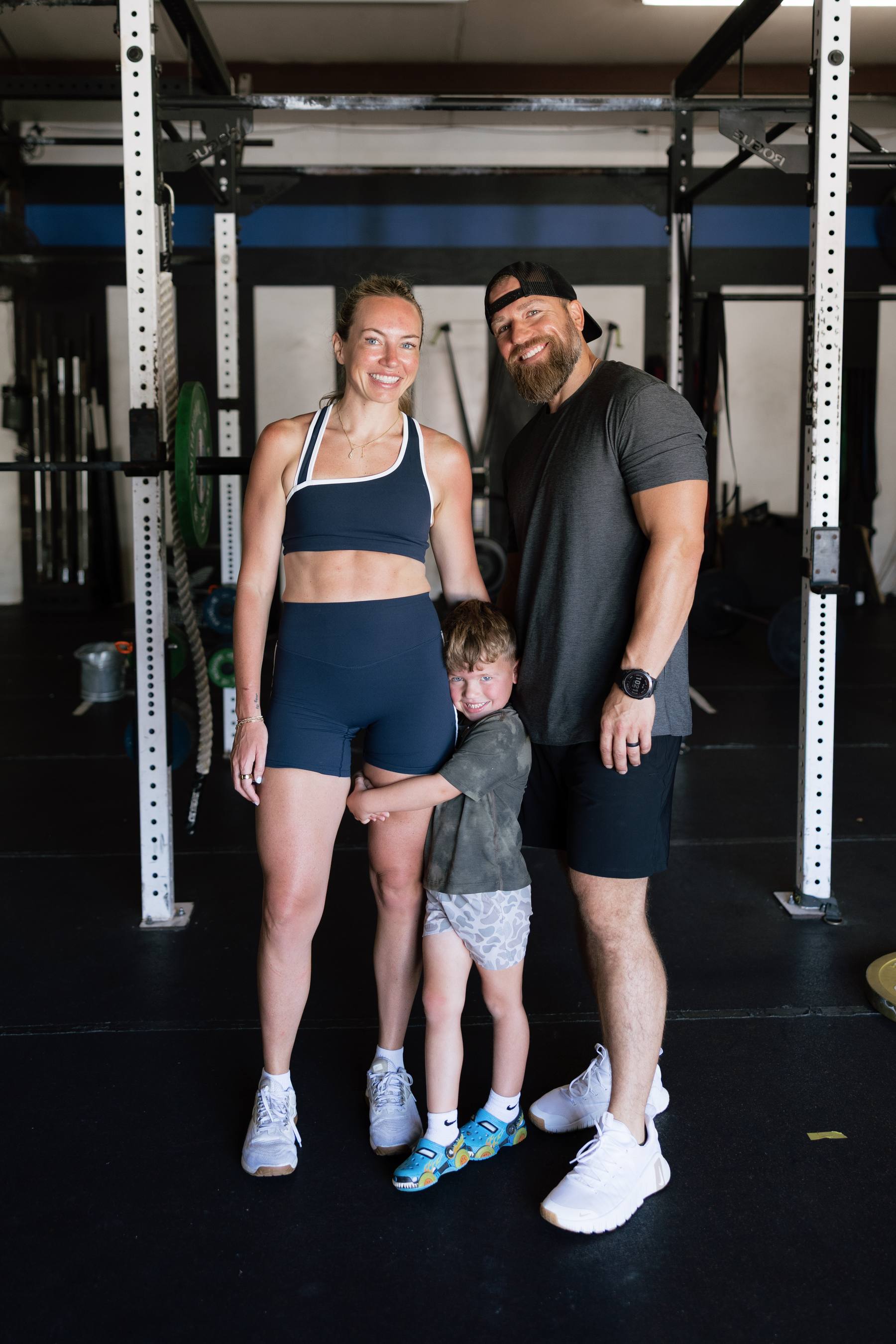 A couple and their young child on the gym floor