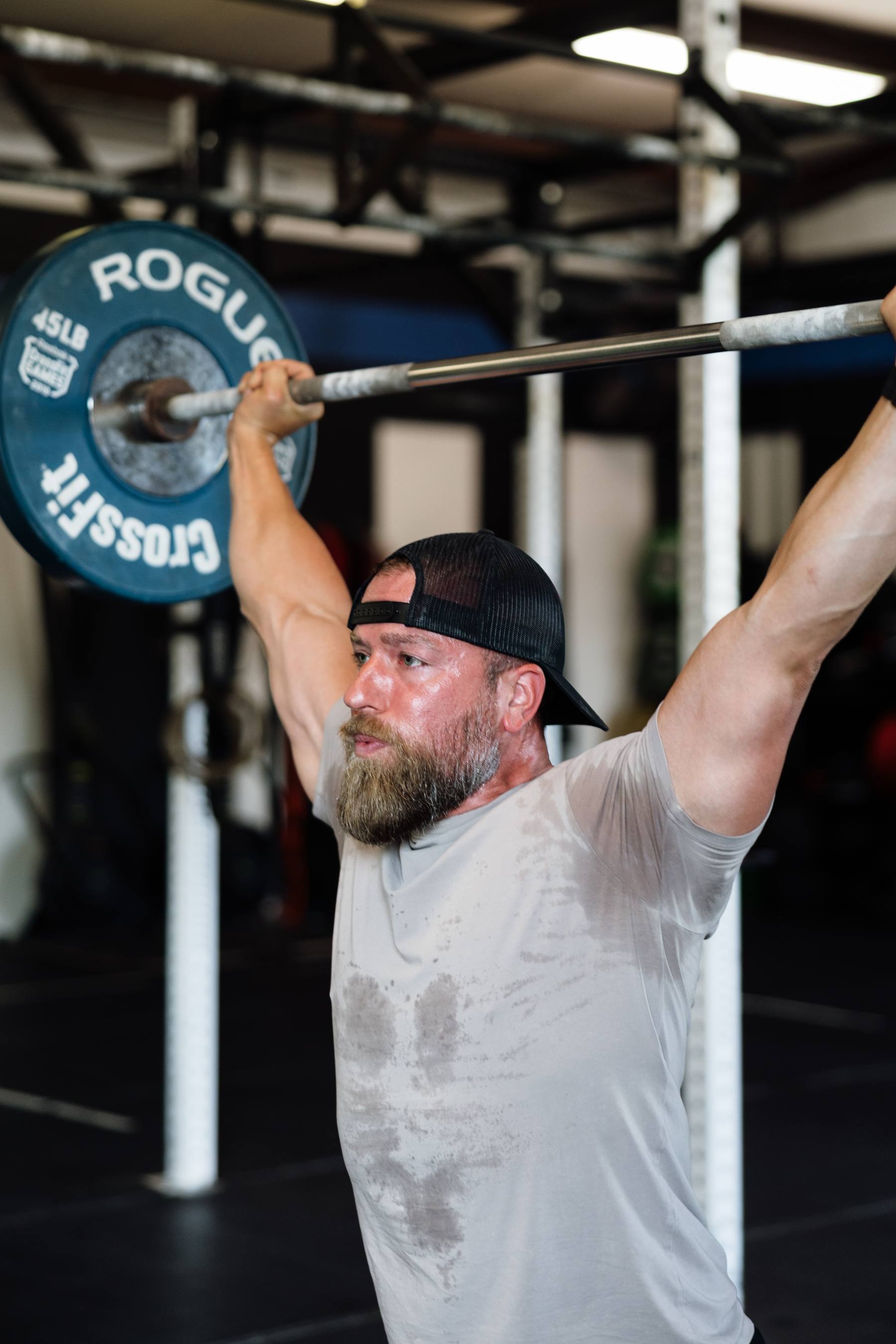 Athlete pressing a loaded barbell overhead at CrossFit Barbell Republic