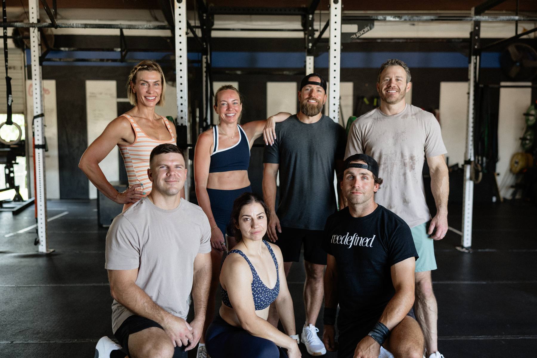 Six members and coaches together on the gym floor